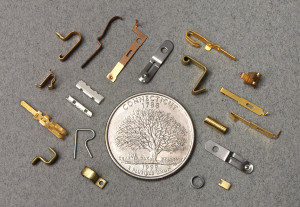 Minature metal stampings arrange around a quarter